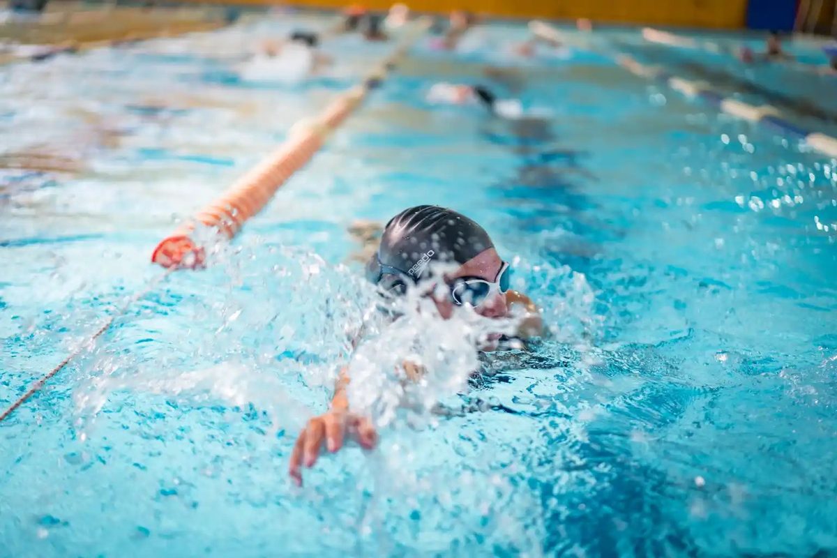 Nadador entrenando estilo libre con gorro en la piscina temperada UCM