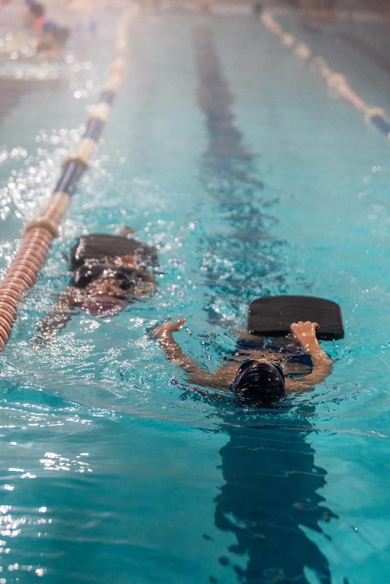 Niños entrenando con tablas de natación en la Piscina Temperada UCM